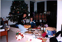 Fionad and Elaine unwrapping presents under the tree